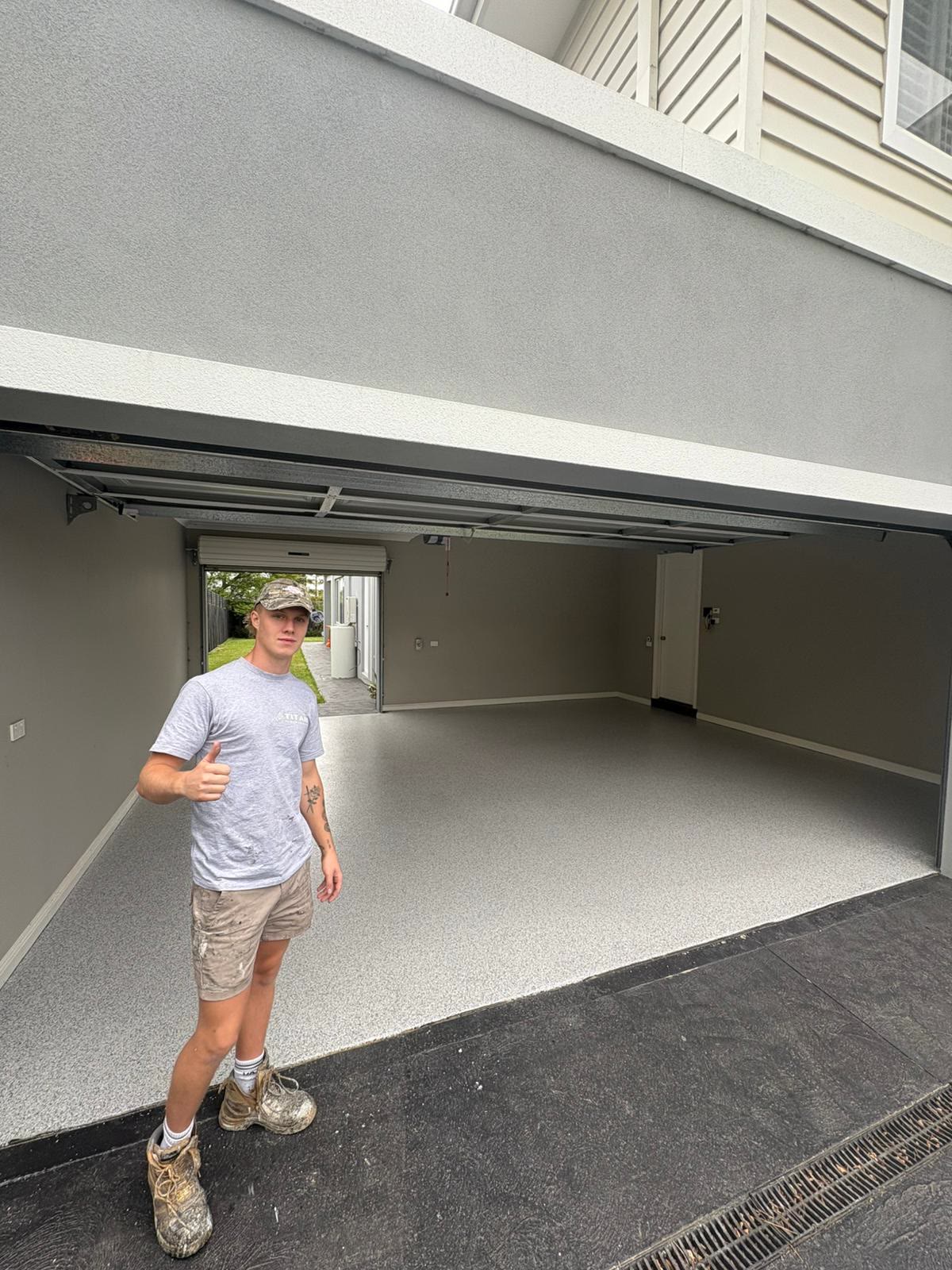 Kobi, owner and lead installer at Titan Floor Coatings, on site at a finished epoxy garage floor