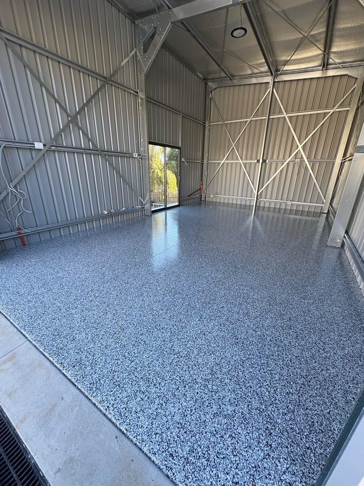 Shed garage with a grey epoxy flake floor